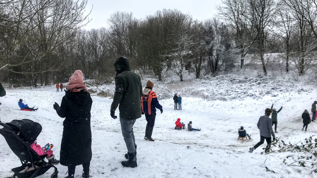 Ouders en kinderen spelen in sneeuw
