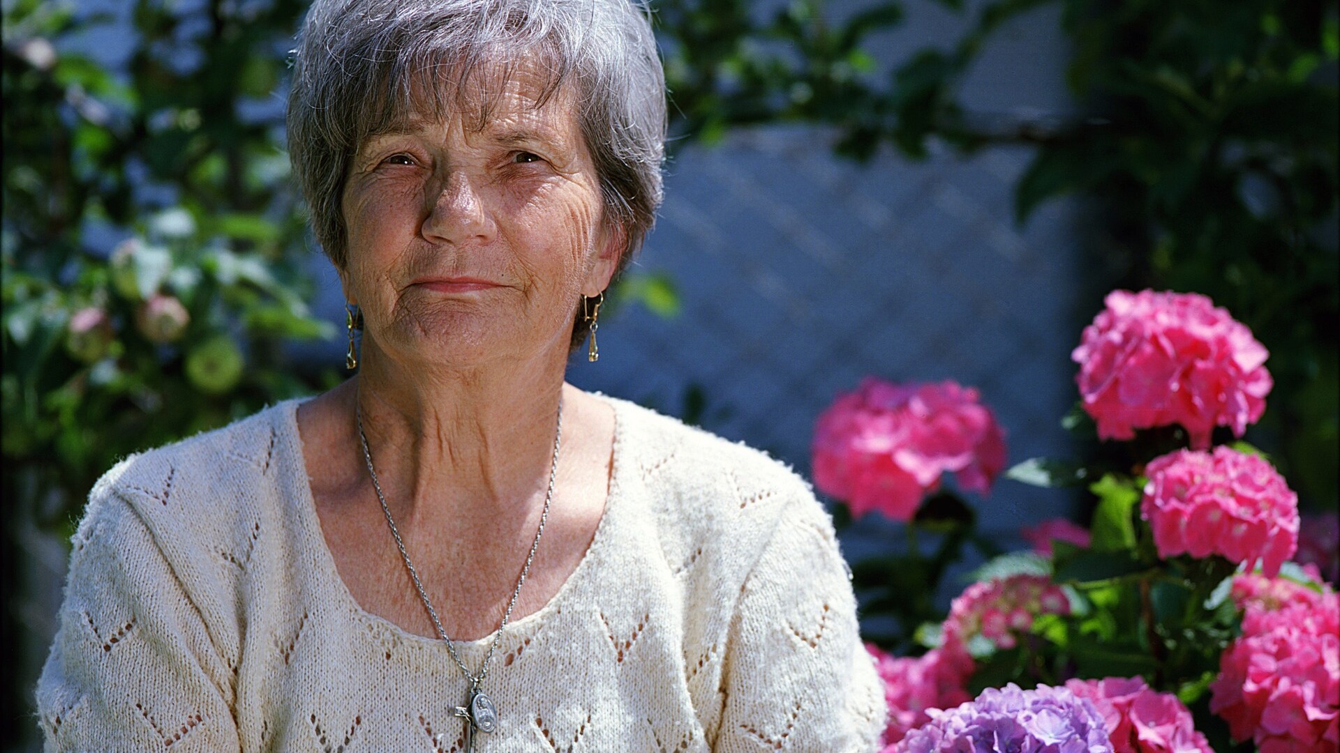 Oudere dame bij bloemen